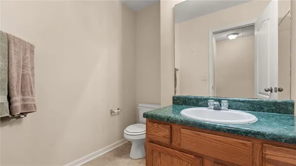 a bathroom with a granite countertop sink toilet and a mirror