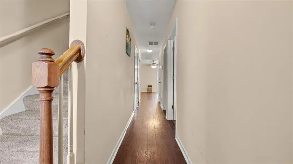 a view of a hallway with wooden floor and staircase