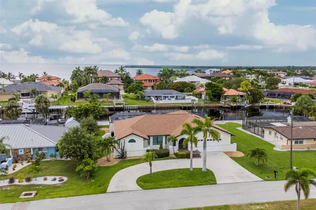 a front view of a house with a yard and palm trees
