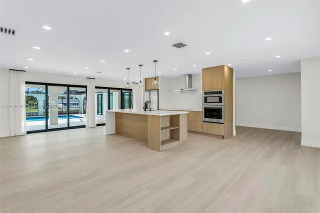 a kitchen with kitchen island a sink appliances and a counter top space