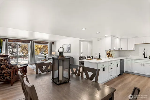 a large white kitchen with lots of counter top space and stainless steel appliances