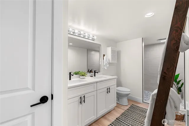 a bathroom with a sink a toilet a mirror and shower