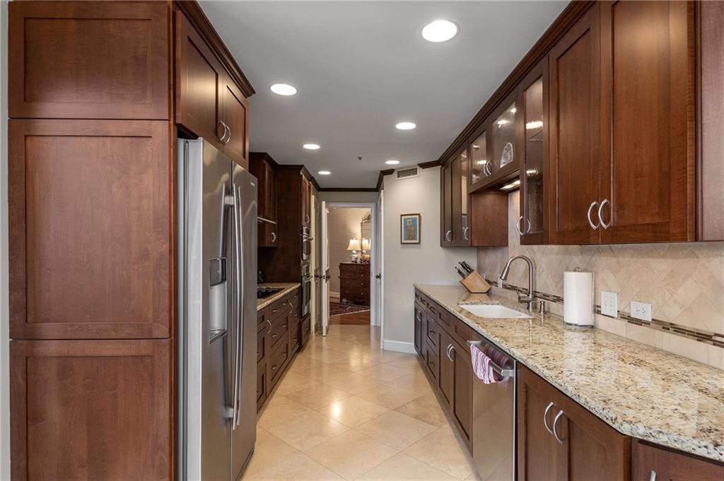 2660 Peachtree Road Northwest, Unit 16F Atlanta, GA 30305 - Photo 18 of 56 a large kitchen with a large counter top a sink and stainless steel appliances