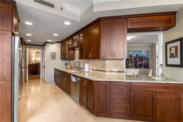 a large kitchen with stainless steel appliances wooden cabinets and a granite counter tops