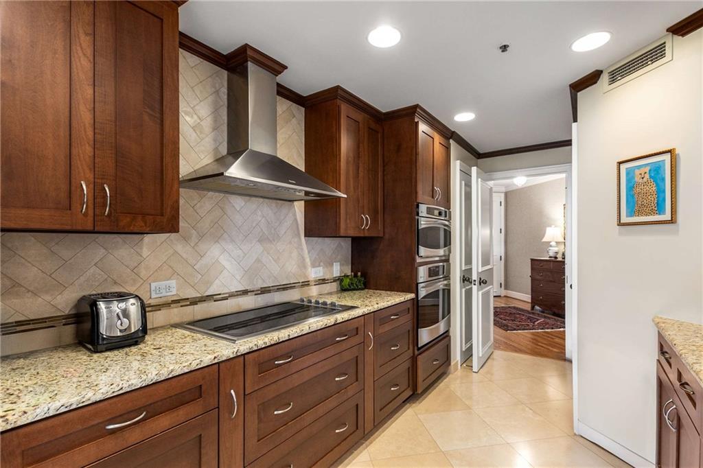 2660 Peachtree Road Northwest, Unit 16F Atlanta, GA 30305 - Photo 21 of 56 a kitchen with granite countertop stainless steel appliances a sink stove and refrigerator