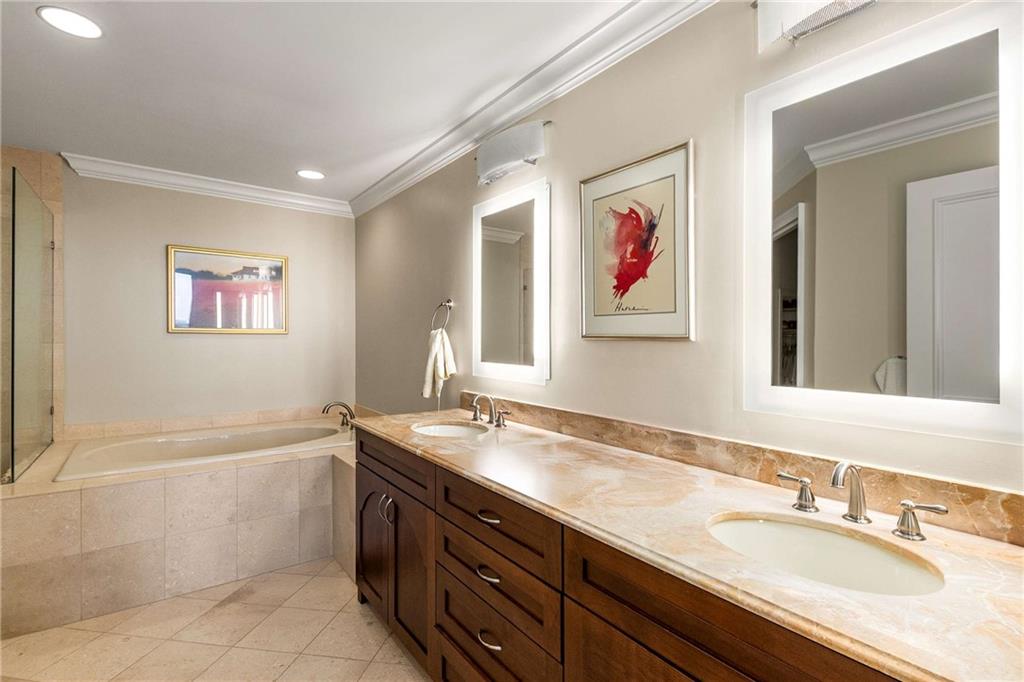 2660 Peachtree Road Northwest, Unit 16F Atlanta, GA 30305 - Photo 27 of 56 a bathroom with a granite countertop tub sink and mirror