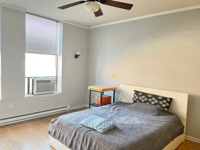a bedroom with a bed and wooden floor