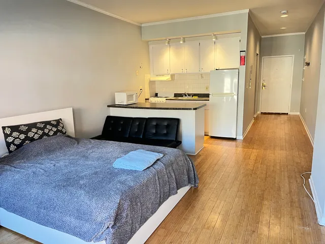 a large bedroom with a bed and wooden floor