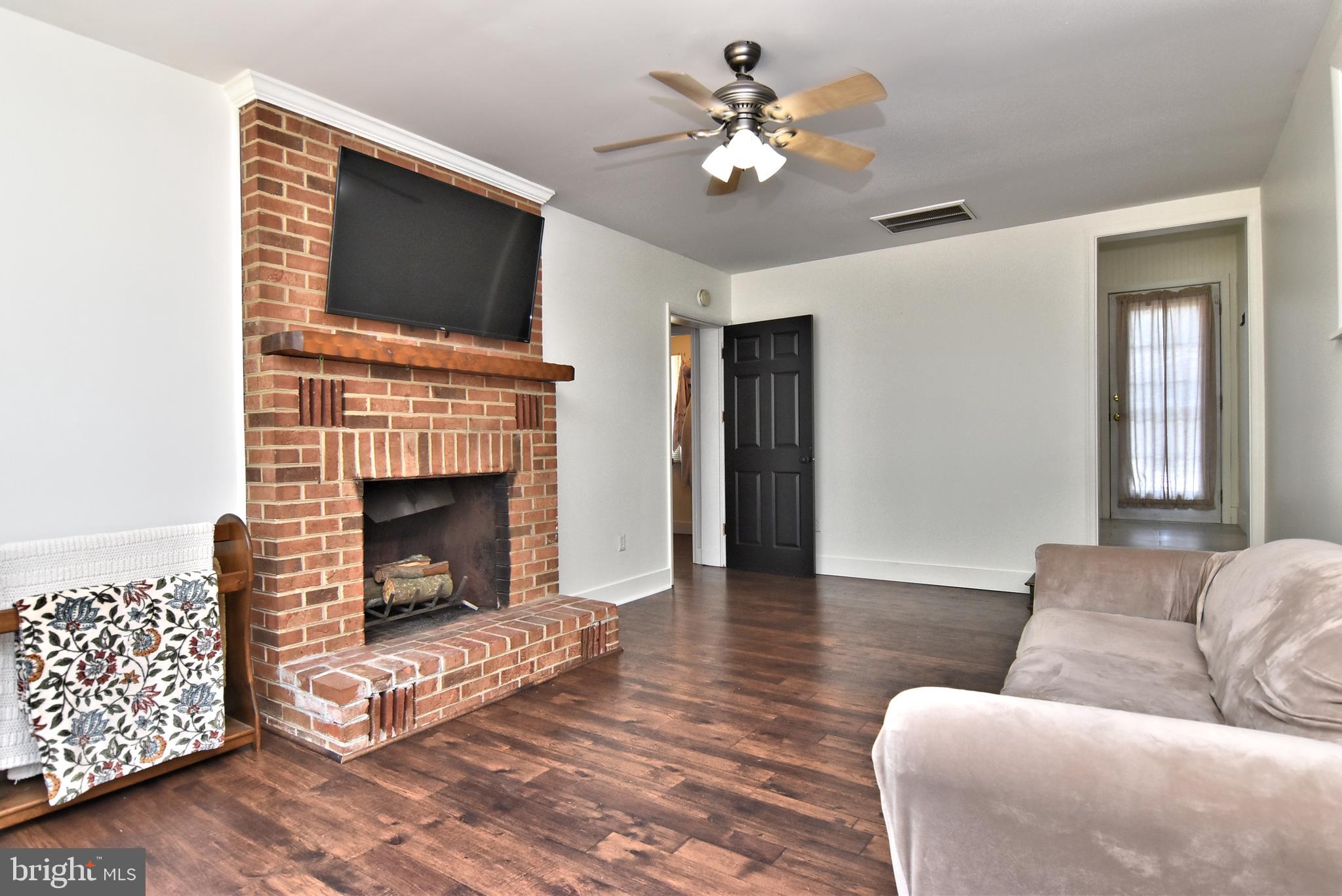 9012 Concord Road Seaford, DE 19973 - Photo 11 of 24 a living room with furniture a flat screen tv and a fireplace