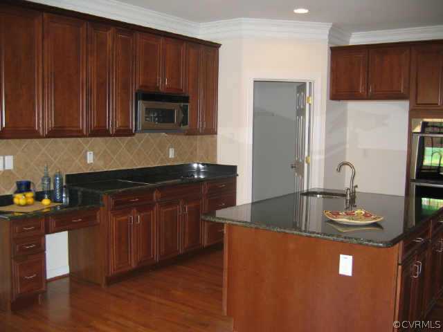 1213 Gravatt Way Midlothian, VA 23114 - Photo 7 of 9 a kitchen with granite countertop wood cabinets stainless steel appliances and a sink