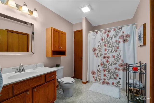 a bathroom with a toilet sink and shower curtain