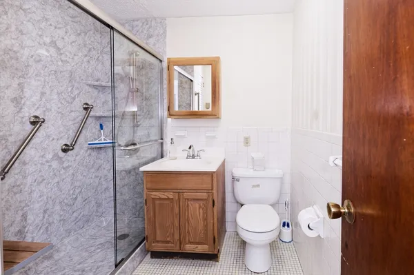 a bathroom with a toilet a sink and mirror