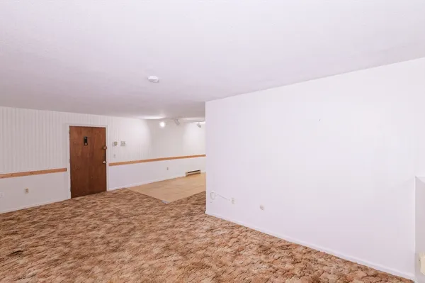 a view of a room with a bed and wooden floor
