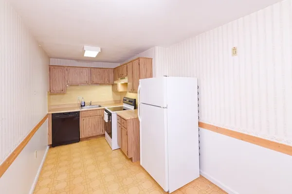 a kitchen with a refrigerator sink and cabinets