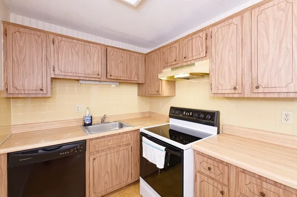 a kitchen with stainless steel appliances granite countertop a sink a stove a refrigerator and cabinets