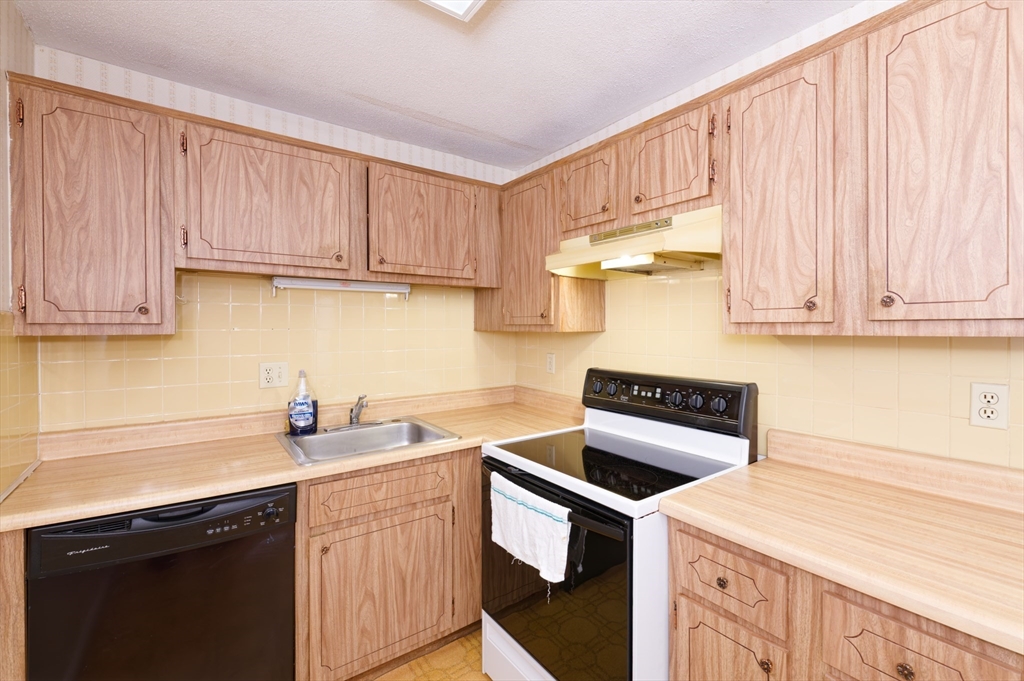 39 Pleasant Street, Unit B4 Northborough, MA 01532 - Photo 9 of 24 a kitchen with stainless steel appliances granite countertop a sink a stove a refrigerator and cabinets