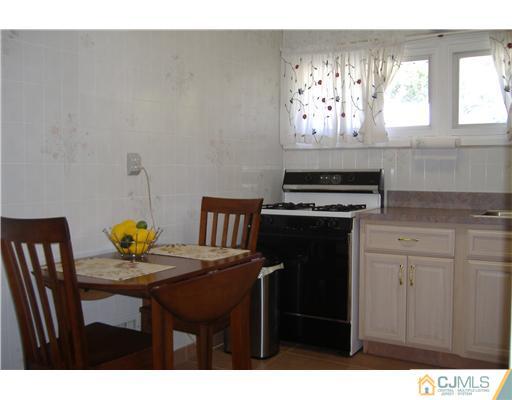 7 Ridge Road Old Bridge, NJ 08857 - Photo 8 of 15 a kitchen with stainless steel appliances a stove a table and a refrigerator