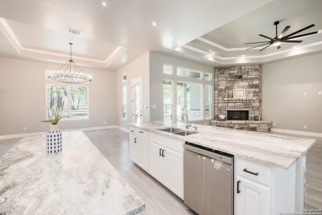 a large kitchen with kitchen island a large counter top stainless steel appliances and cabinets