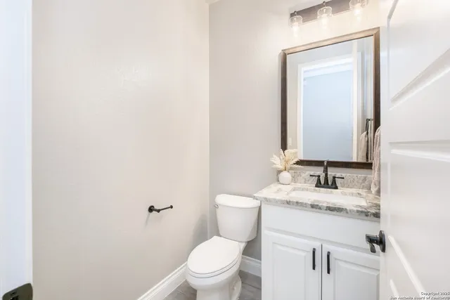 a bedroom with a large bed and a chandelier fan