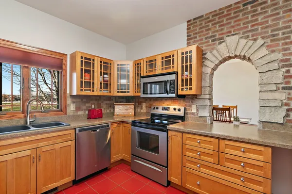 a kitchen with stainless steel appliances granite countertop a sink stove and cabinets