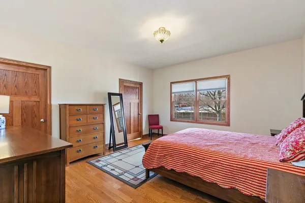 a bedroom with a bed and dresser with mirror