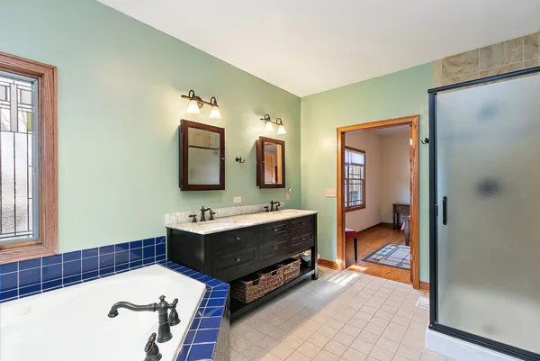 a bathroom with a tub sink and mirror