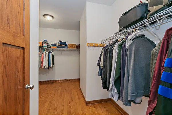 a view of walk in closet with clothes and shoes