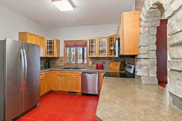 a kitchen with stainless steel appliances granite countertop a refrigerator a stove and a sink