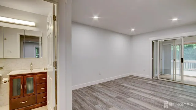 a view of hallway with wooden floor and cabinet