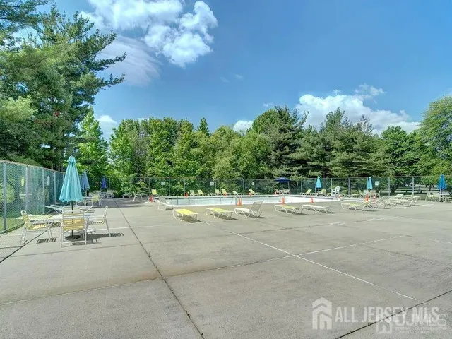 a backyard of a house with table and chairs plants and large trees