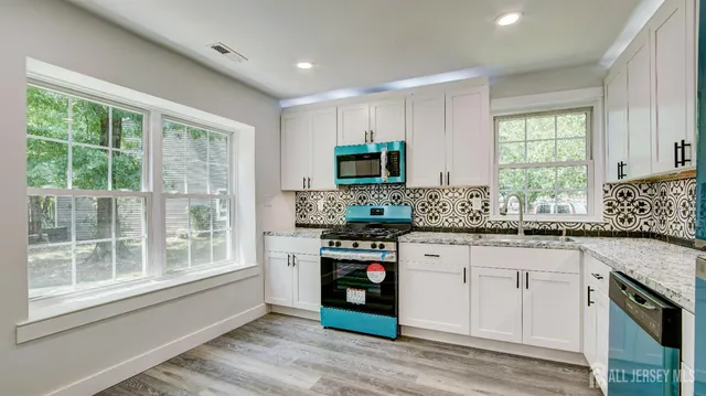 a kitchen with stainless steel appliances granite countertop a stove a sink and a microwave