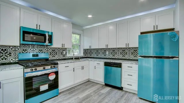 a kitchen with granite countertop cabinets stainless steel appliances and wooden floor