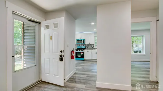 a view of a hallway view with wooden floor and windows