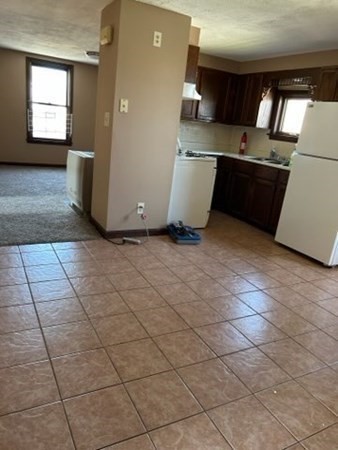 355 Field Street, Unit 2 Fall River, MA 02721 - Photo 2 of 11 a kitchen with a sink a stove and a refrigerator