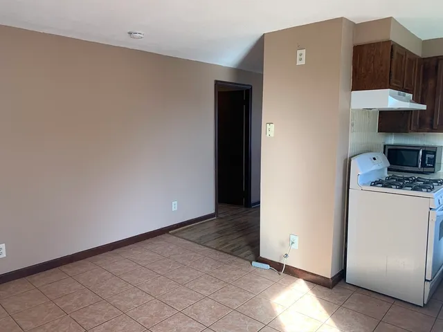 a view of a kitchen with cabinets and a stove top oven