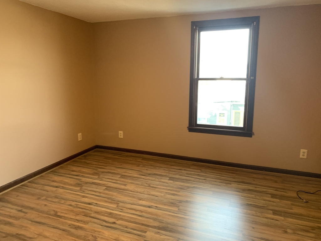 355 Field Street, Unit 2 Fall River, MA 02721 - Photo 6 of 11 an empty room with wooden floor and windows