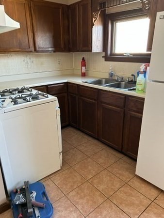 355 Field Street, Unit 2 Fall River, MA 02721 - Photo 7 of 11 a kitchen with a sink a stove cabinets and wooden floor