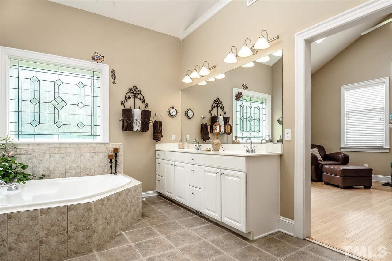299 Howard Tant Road Zebulon, NC 27597 - Photo 14 of 25 The huge vaulted Master Bath features a skylight, jetted tub under leaded glass window, huge tiled shower, double sinks, neutral tile floor & private toilet rm.