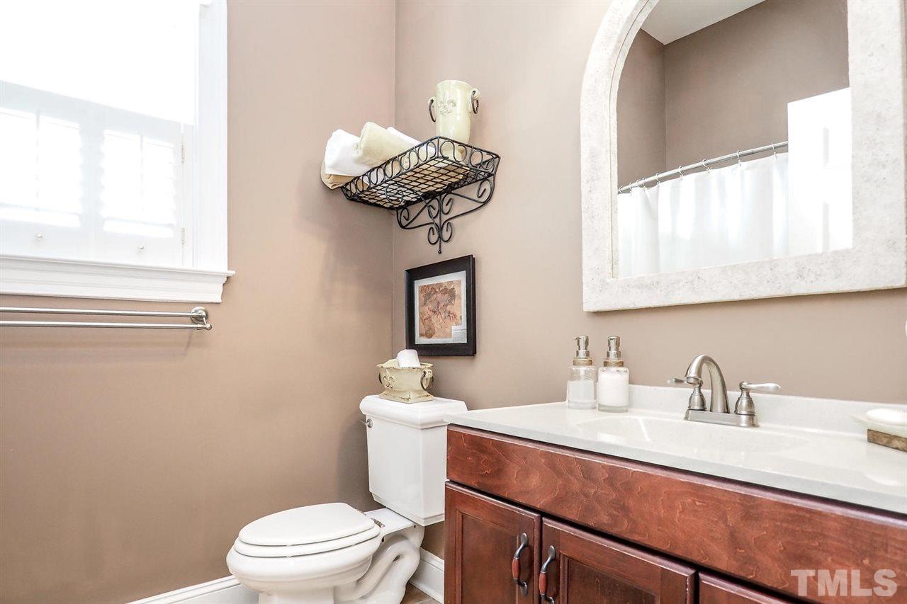 299 Howard Tant Road Zebulon, NC 27597 - Photo 17 of 25 The 2 Bedrooms share the hall Bath w/neutral tile floor, solid surface vanity top & shuttered, arched window.