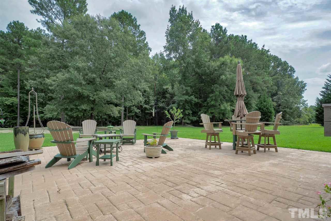 299 Howard Tant Road Zebulon, NC 27597 - Photo 22 of 25 The Screened Porch leads out to the nice Deck w/Trex decking, which steps down to the huge stamped concrete Patio.