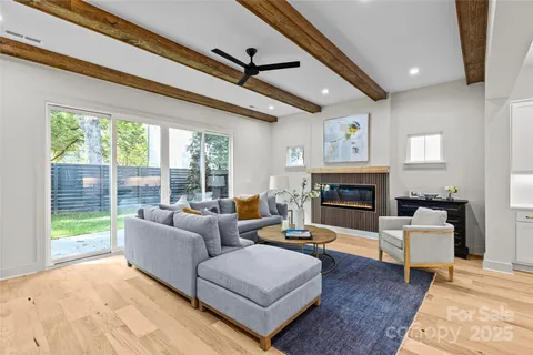 a living room with furniture large window and a fireplace