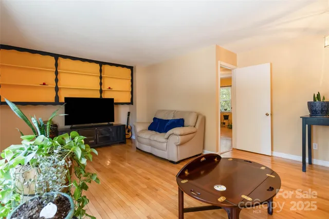 a living room with furniture a flat screen tv and a floor to ceiling window