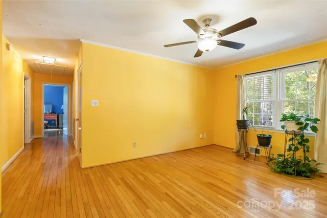 a view of a livingroom with wooden floor and a ceiling fan