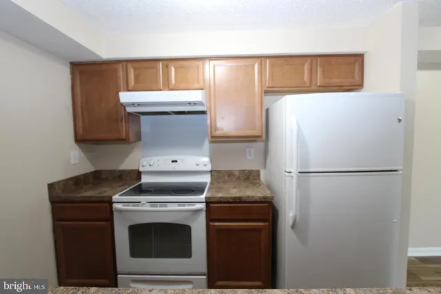 a kitchen with sink stove and refrigerator