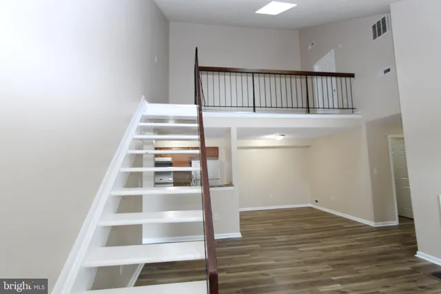a view of a hallway with wooden floor and windows