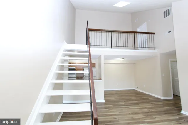 a view of a hallway with wooden floor and staircase