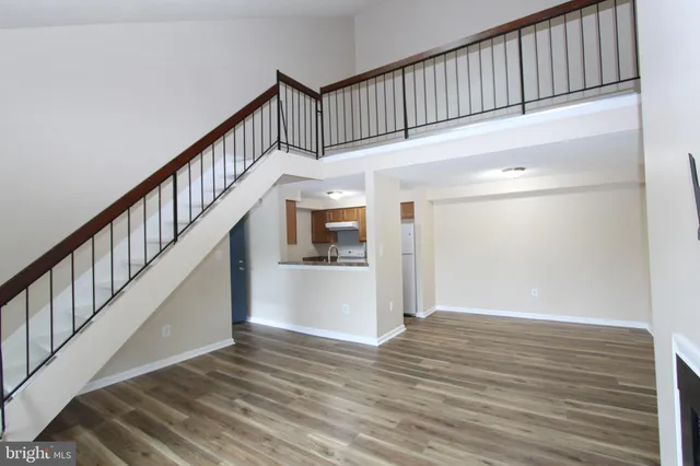 a view of staircase with wooden floor and white walls