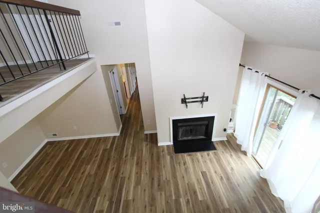 a view of a livingroom with wooden floor and a fireplace