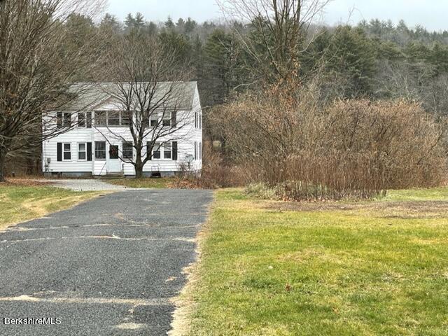 32 North Main Road Otis, MA 01253 - Photo 5 of 30 a front view of a house with a yard and trees