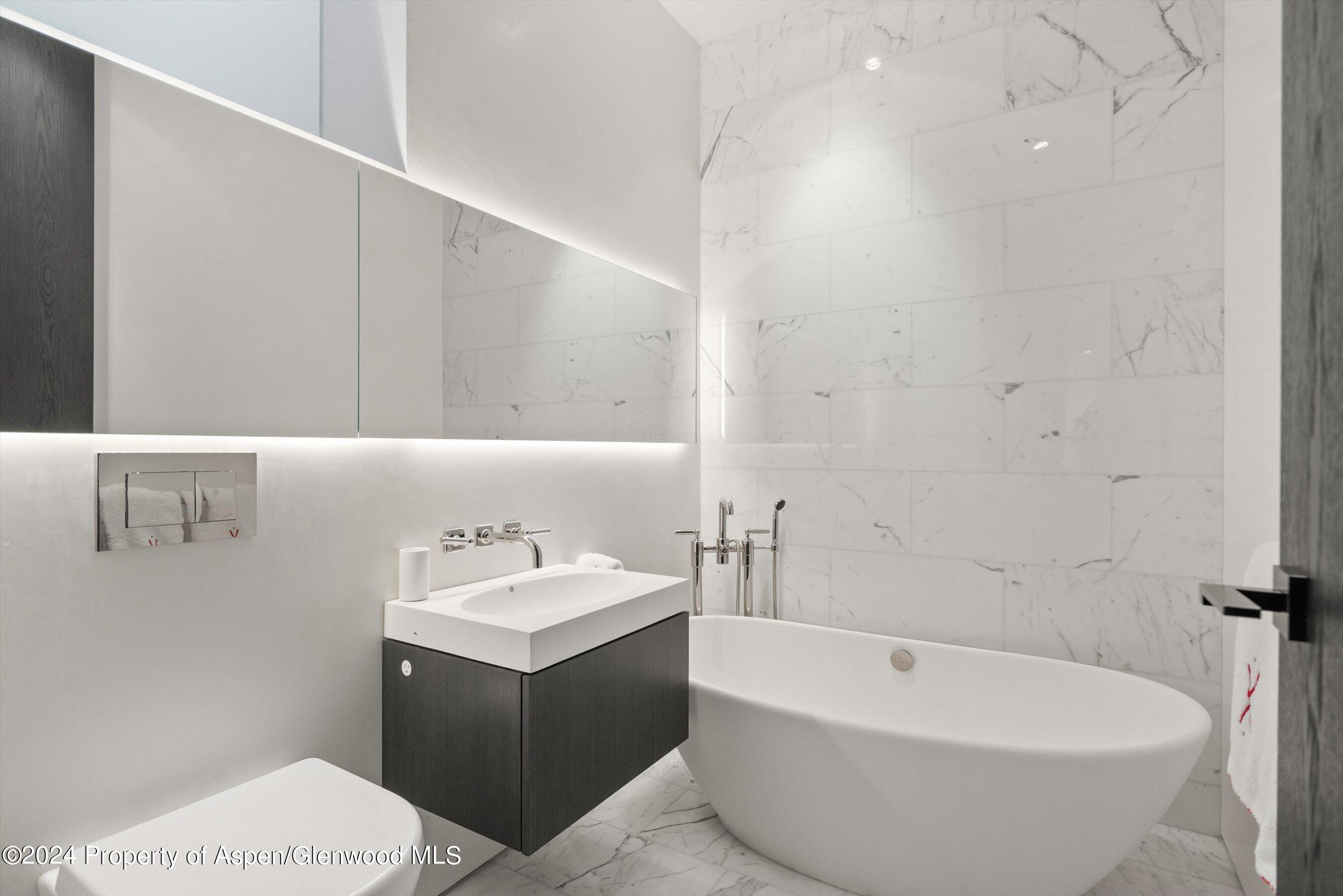 600 Nell Erickson Road Aspen, CO 81612 - Photo 32 of 40 a bathroom with a bathtub a sink a toilet and a mirror